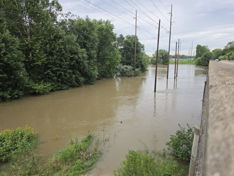The flooded White River runs high beneath the Southport Road bridge in Indianapolis on August 15, 2026