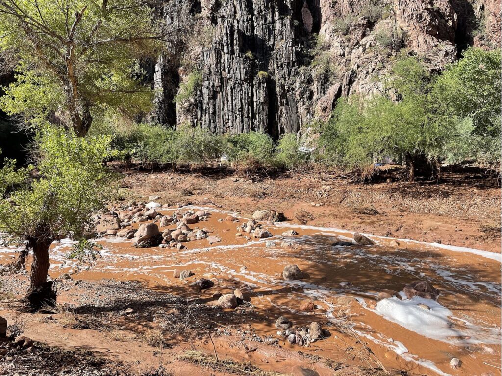 Muddy water and boulders in Bright Angel Creek the day after the Grand Canyon flash flood
