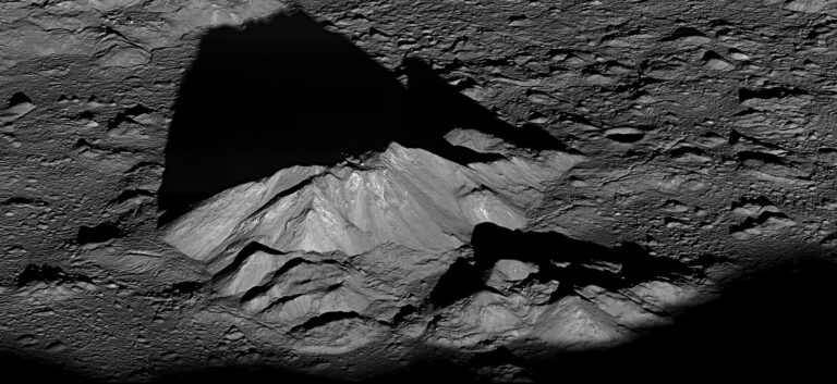 The central peak of the moon's Tycho crater casts a long shadow in an oblique view captured by NASA's Lunar Reconnaissance Orbiter