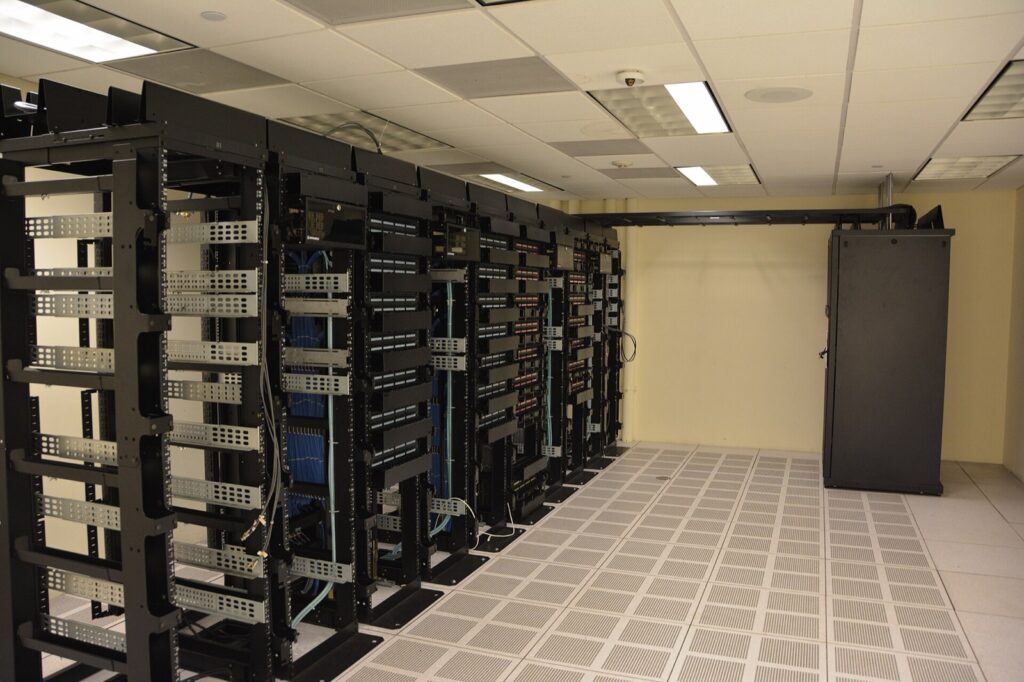Rows of black server racks with network cabling in a data center room
