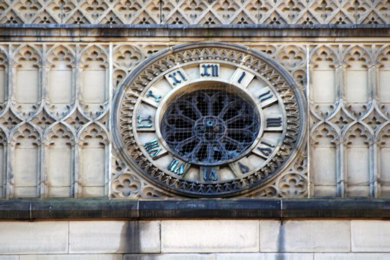 Ornate stone clock face with Roman numerals set into the tower wall of St Luke's Church in Liverpool