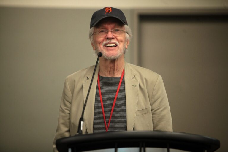 Actor Tom Skerritt speaking into a microphone at a 2014 fan event in Phoenix